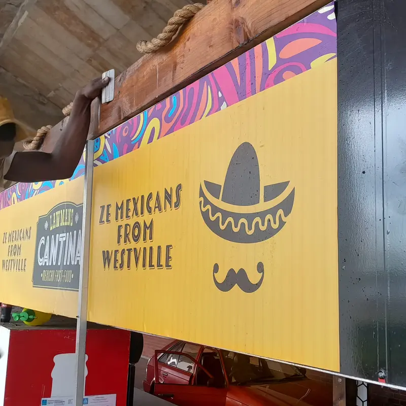 Professional large-format food trailer vinyl application featuring coordinated illustrations and bright colours to attract potential customers.