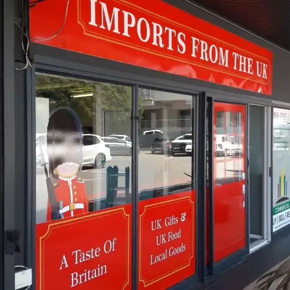 ustom storefront signage featuring coordinated fascia branding, promotional lettering and printed window graphics for a professional retail appearance.