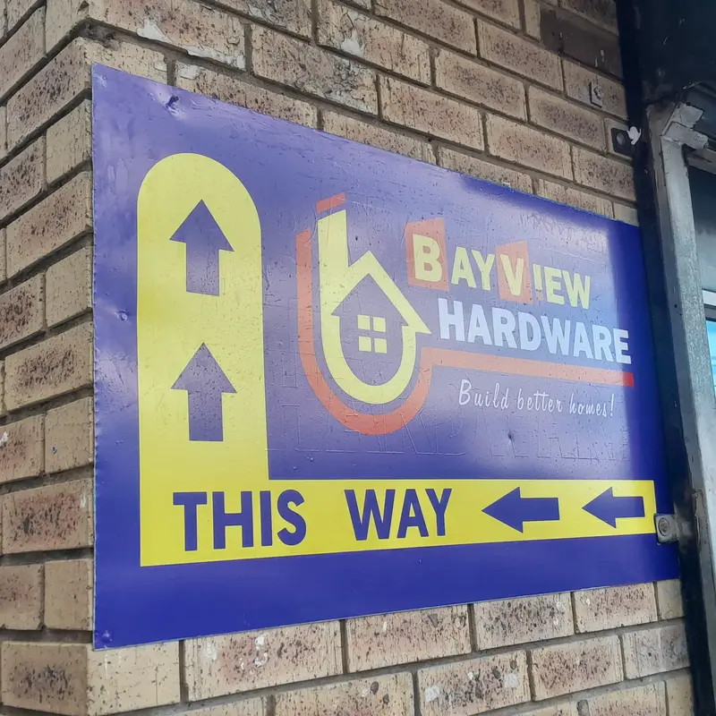 Custom wall-mounted directional signage featuring prominent business identification and navigation arrows to help customers locate the premises.