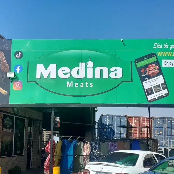 Custom retail storefront signage featuring vibrant green corporate branding, large business lettering and product advertising graphics.