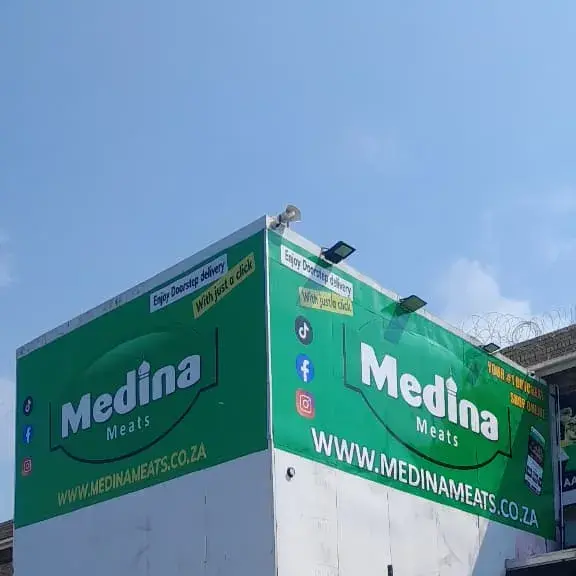 Large-format commercial building signage featuring prominent green corporate graphics designed to improve long-distance visibility and brand recognition.